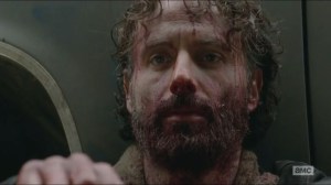 A- Bloodied Rick sits in front of truck