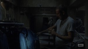 Adaptation- Negan examines a leather jacket at a men's clothing store- AMC, The Walking Dead